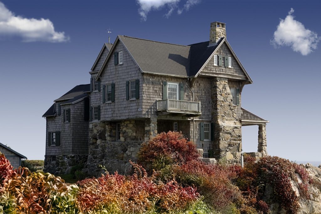 A large stone house with masonry exterior and country house architecture set within a landscape.