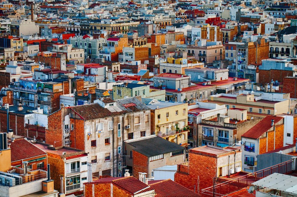 A dense residential area with many rooftops, apartment buildings, and houses spread across an urban neighborhood.