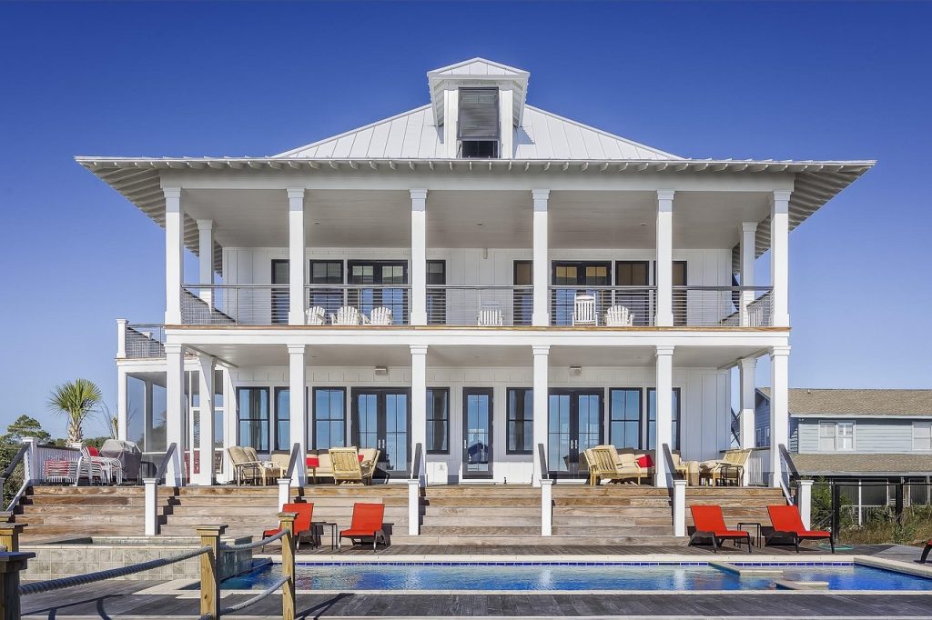 Large modern luxury house exterior with a swimming pool and upscale architectural facade.