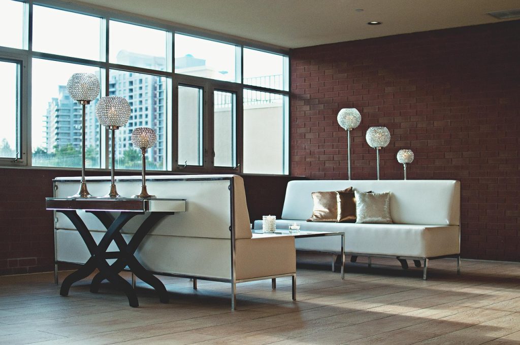 A contemporary apartment living room featuring a sofa, modern furniture, and large windows.