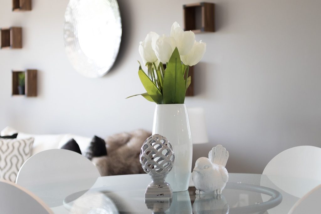 A staged interior room featuring gray décor, white tulips, and coordinated furniture in a home design setting.